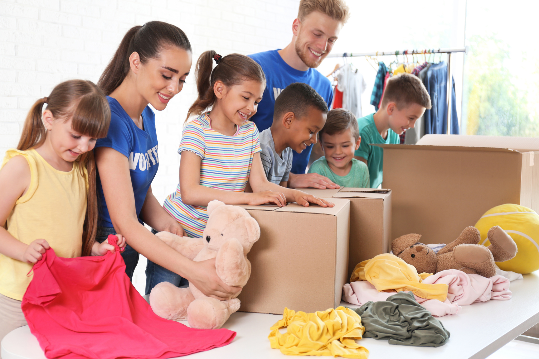 Volunteers with Children Sorting Donation Goods Indoors